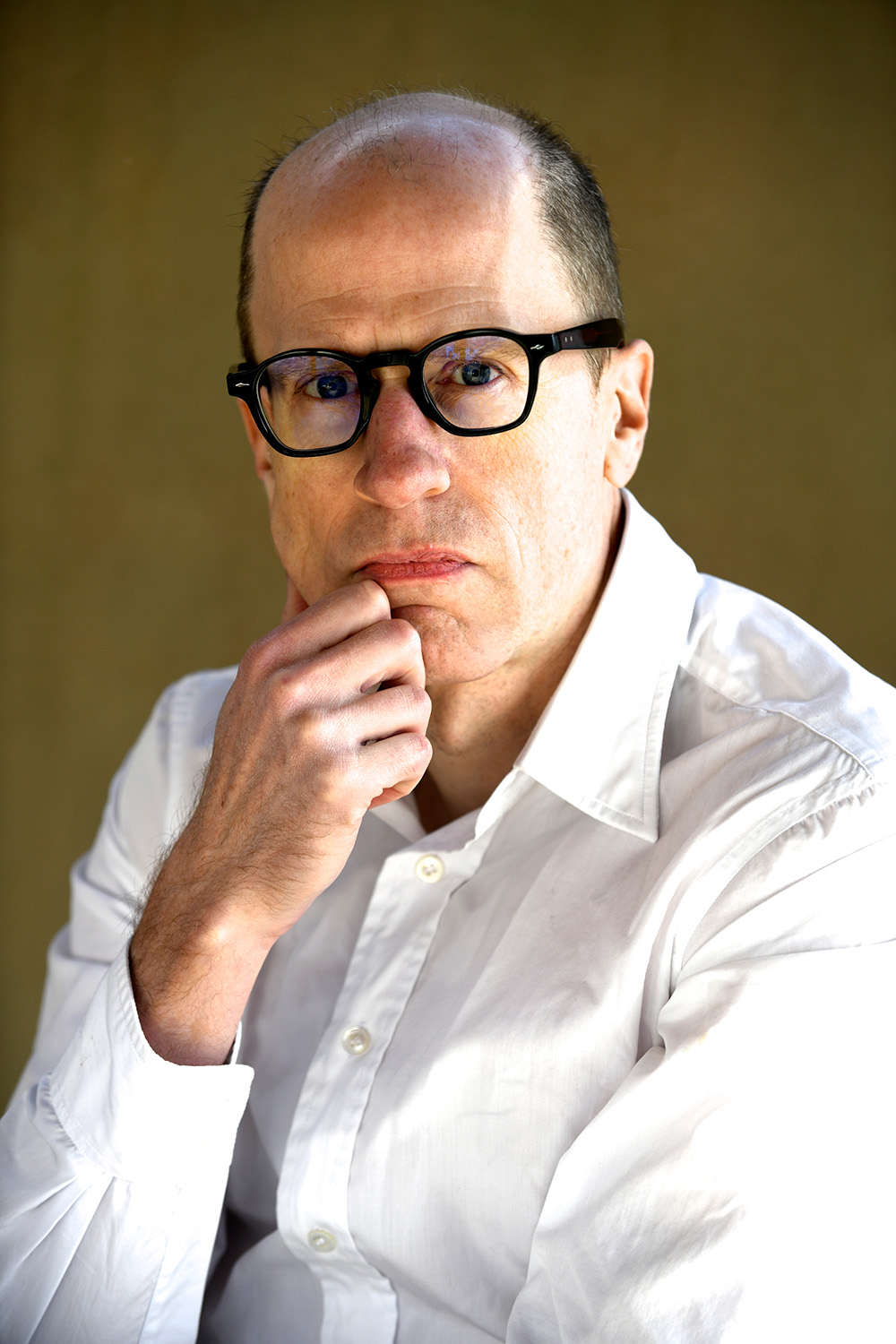 Indoors portrait of Nick Bostrom in a white shirt